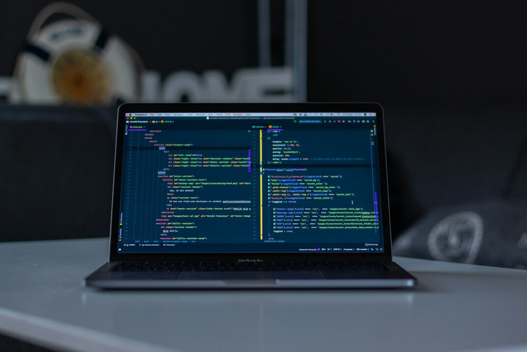 programmer typing code on laptop